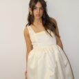 Uma mulher a usar um vestido mini branco de alças e decote reto