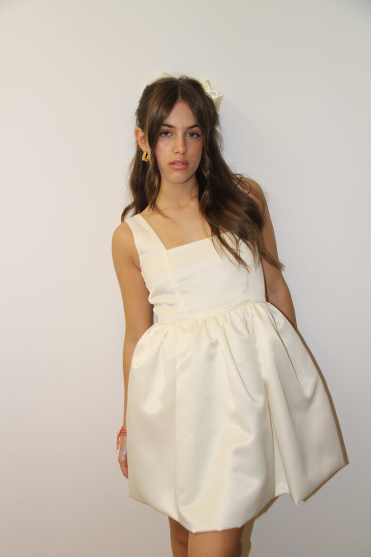 Uma mulher a usar um vestido mini branco de alças e decote reto