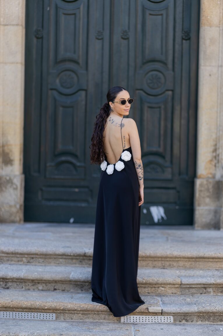 Vestido preto de alças finas com costas abertas e rosas brancas